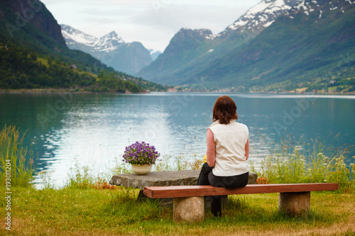Woman tourist relaxing on fjord sea shore, Norway