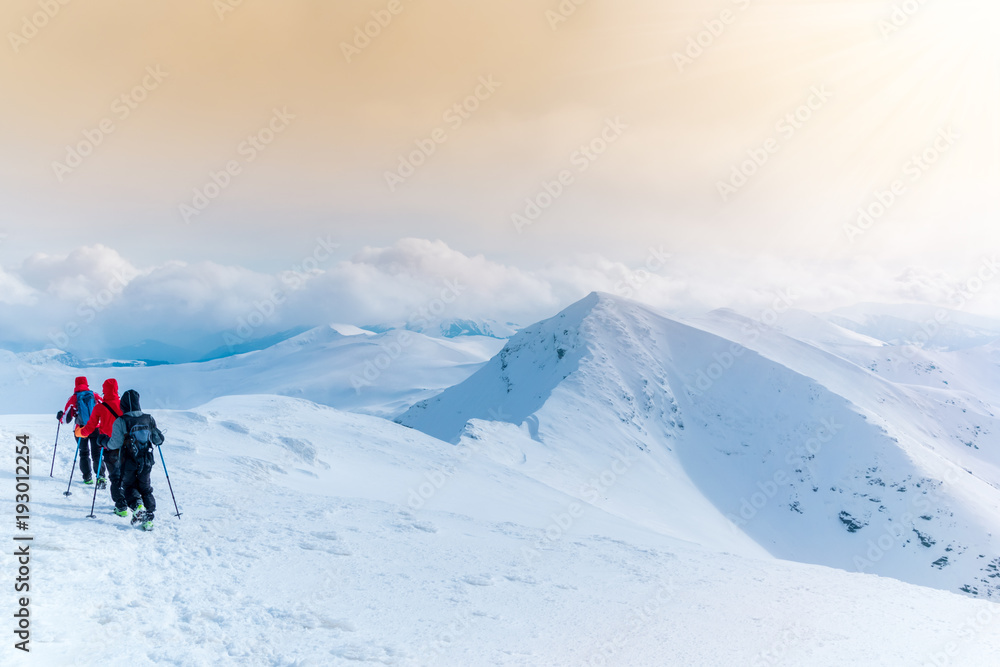 Group of tourists climbing the peaks of Rodnei mountain in winter season in Maramures, Romania