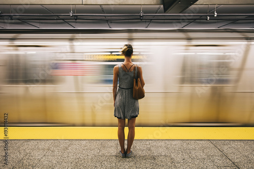 Young woman waiting for subway train in New York City photo