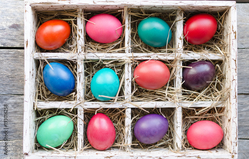 Easter eggs in a wooden box with hay