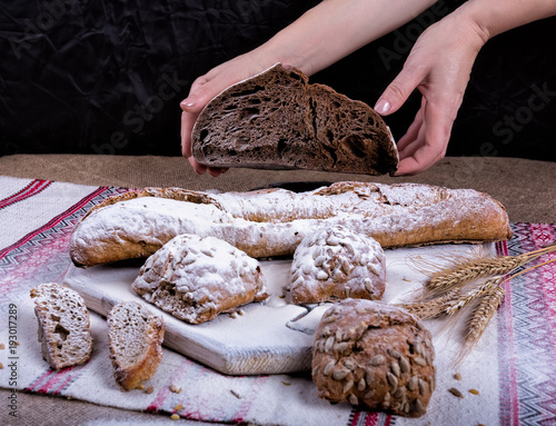 Bread and spikelets are held by hands photo