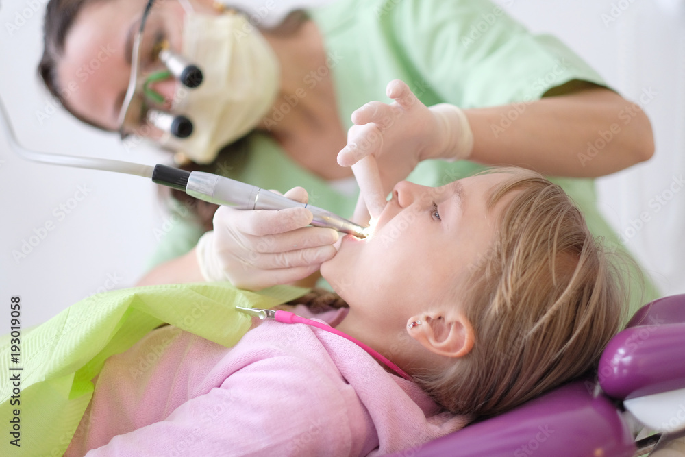 Φωτογραφία A little girl is lying in an armchair at a reception near a dentist