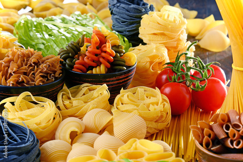Composition with different sorts of pasta on kitchen table