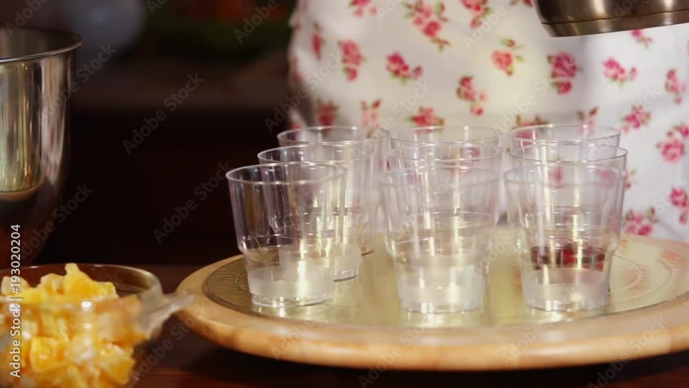 Woman is putting on a cherry jam into cups. Home made dessert for family and friends, on a kitchen Woman is putting on a cherry jam into cups. Home made dessert for family and friends, on a kitchen