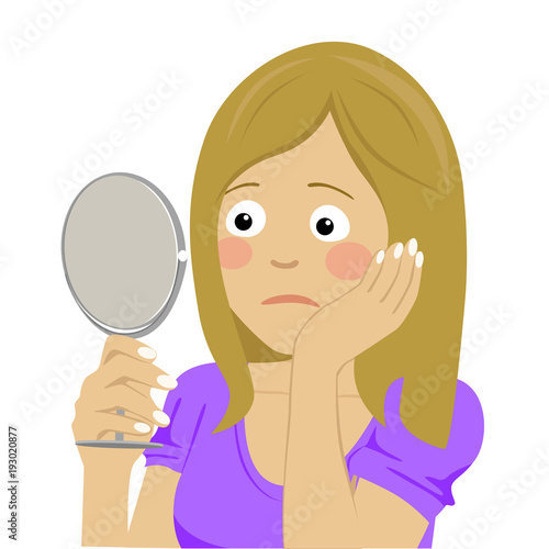 Unhappy and dissatisfied young woman looking at her skin in the mirror