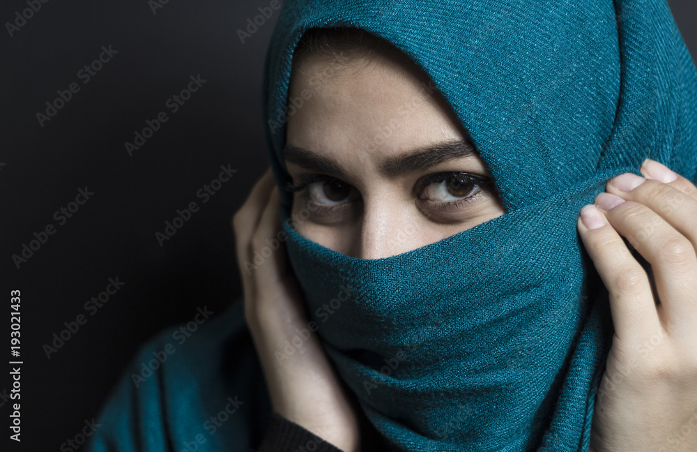 Portrait of a muslim girl in hijab with beautiful eyes on a black background. Portrait of a muslim girl in hijab with beautiful eyes on a black background.