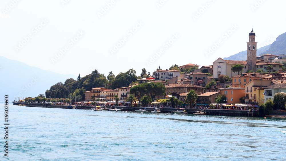 Townscape panorama of lakeside village Limone sul garda with boats and church at Lake Garda, Italy