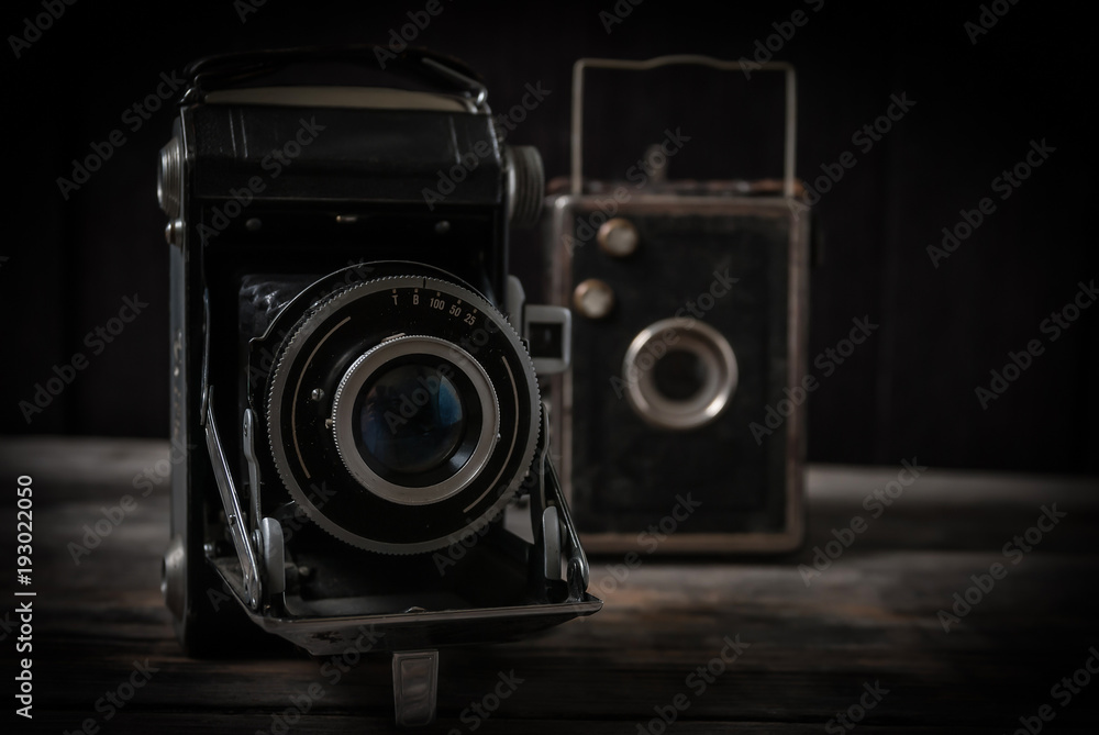 Stare aparaty fotograficzne stojące na starych surowych deskach