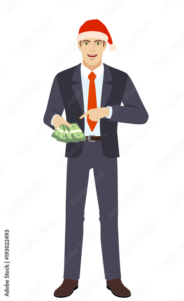 Businessman in Santa hat pointing at money in his hand Businessman in Santa hat pointing at money in his hand