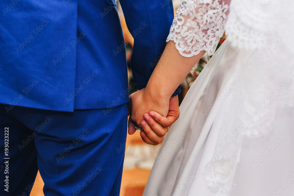 newlyweds in love bride and groom holding hands together at the wedding ceremony newlyweds in love bride and groom holding hands together at the wedding ceremony