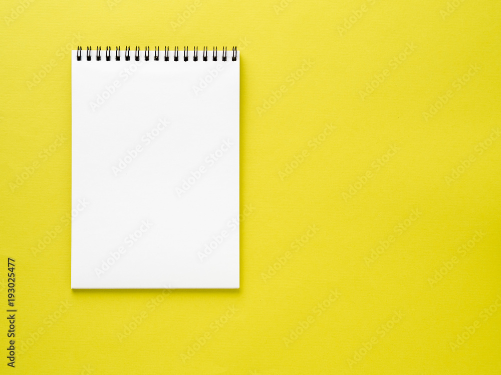 Blank notepad white page on yellow desk, color background. Top view, empty space for text. Blank notepad white page on yellow desk, color background. Top view, empty space for text.