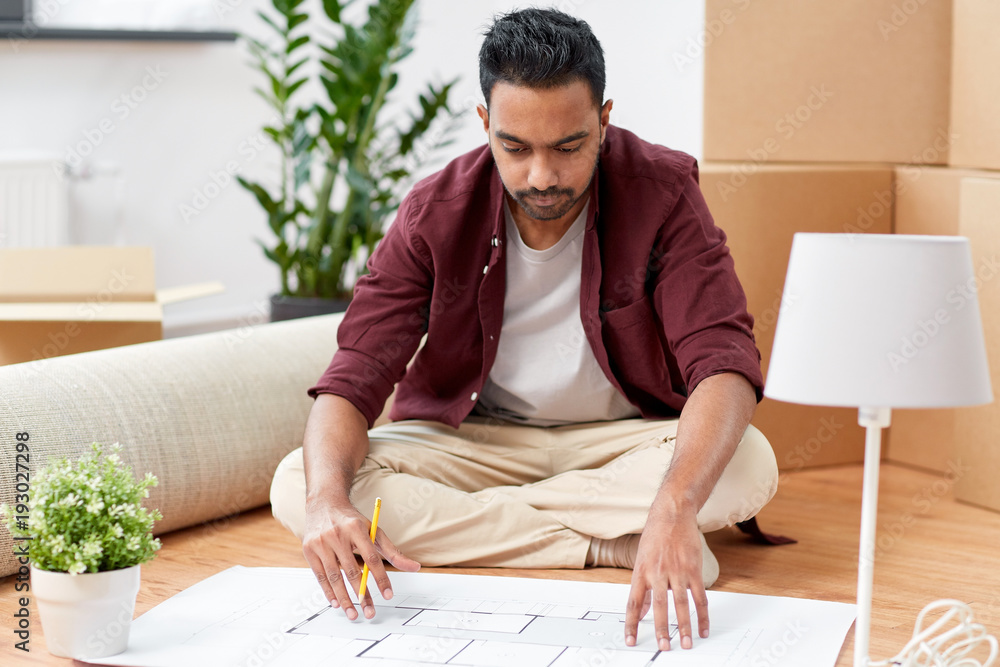 man with blueprint and boxes moving to new home man with blueprint and boxes moving to new home