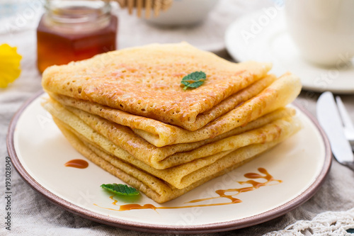 Stack of thin pancakes crepes with caramel topping
