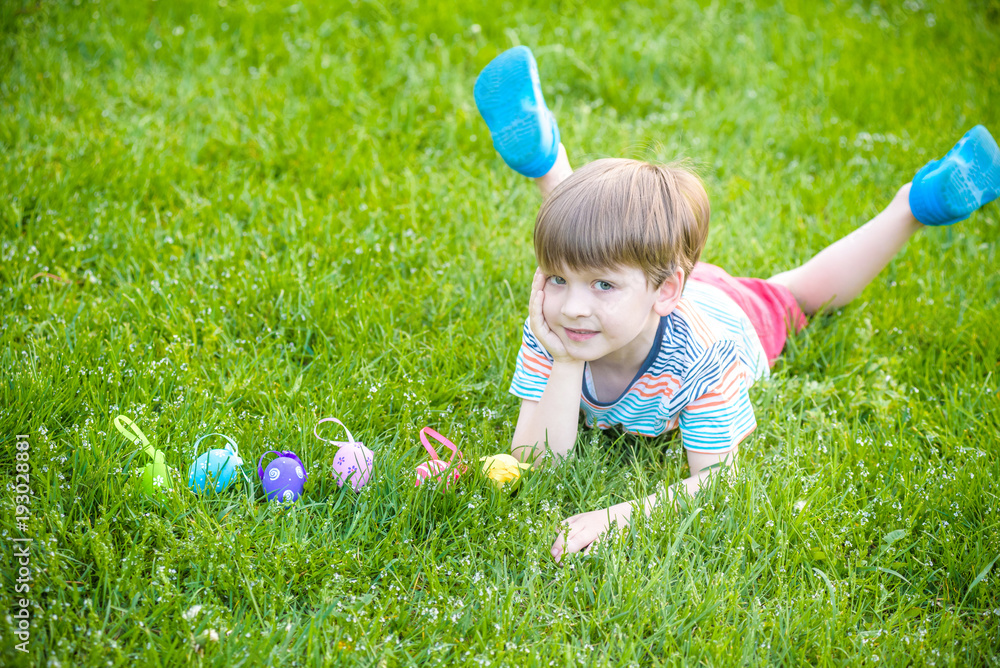 Little boy hunting for easter egg in spring garden on Easter day. Cute little child with traditional bunny celebrating feast Little boy hunting for easter egg in spring garden on Easter day. Cute little child with traditional bunny celebrating feast