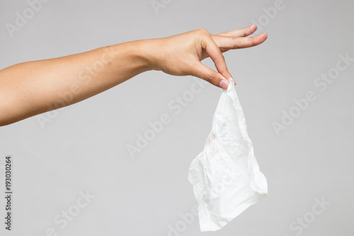 A hand pinches tissue isolate on white background.