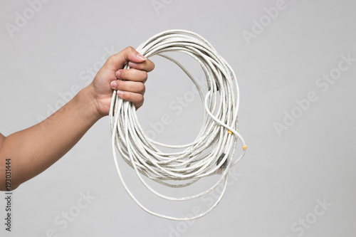 A hand holds cable isolated on white background .
