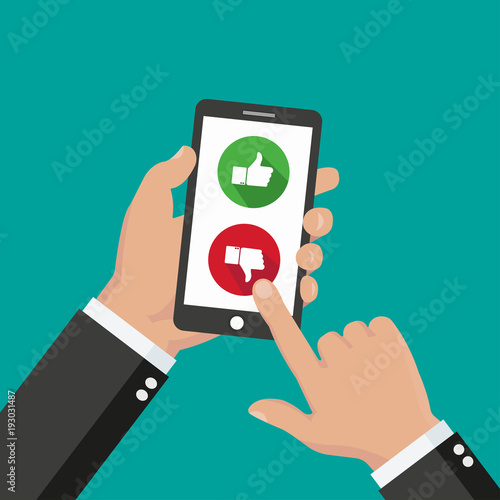 Website rating feedback and review concept. Hand holding and pointing to a smartphone with like and dislike