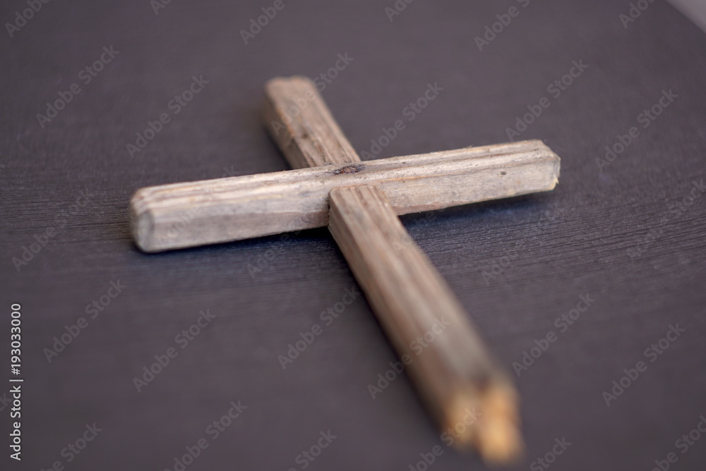 old wooden cross on a textured background old wooden cross on a textured background