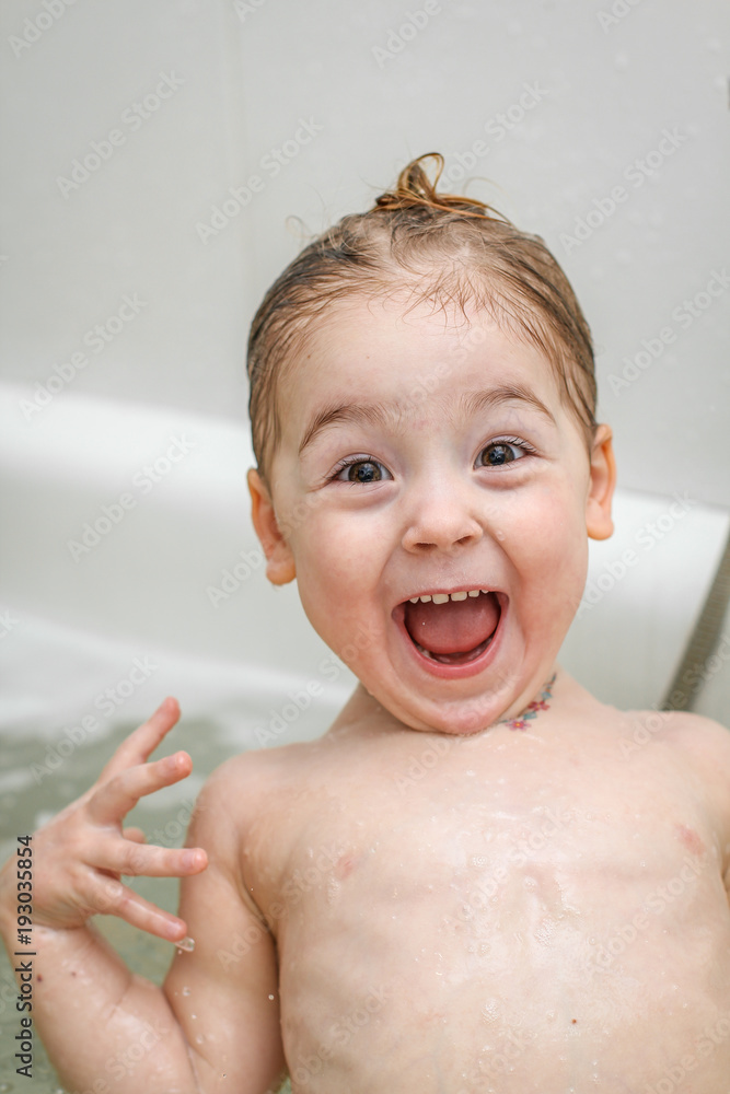A little girl makes funny faces in the bath A little girl makes funny faces in the bath