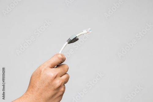A hand holding LAN cord isolated on white background.