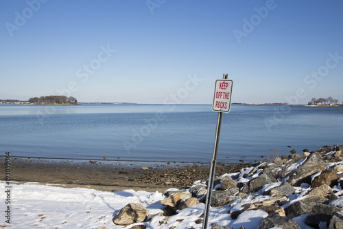 keep off rocks sign on a beach