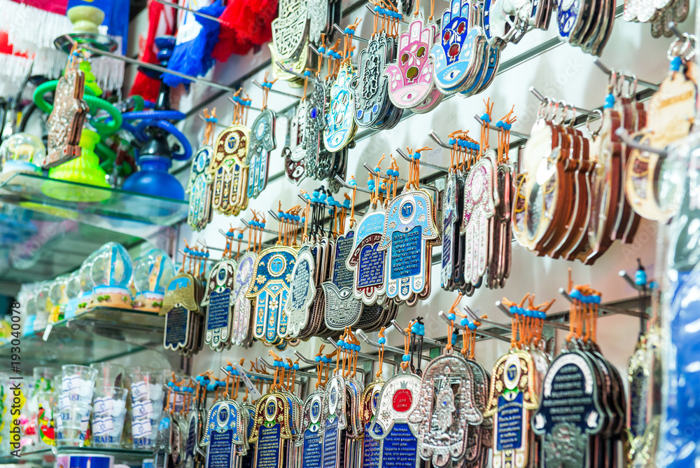 Different jewish souvenirs as Hamsa with Shalom (Peace) and other sale at the popular marketplace in Tel Aviv, Israel. Selective focus.