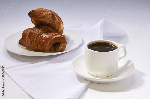 Coffee cup with croissant. Breakfast meal with fresh coffee and french pastry on white