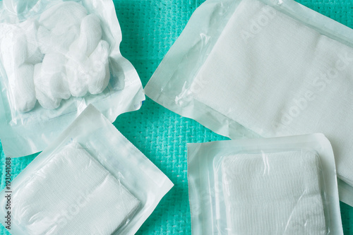 Картината върху платно White medical cotton gauze in sterile packaging on green background