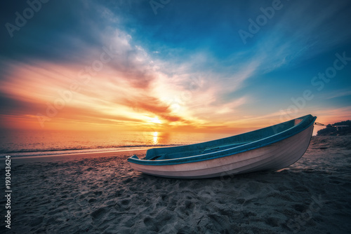 Boat on the beach and beautiful sunrise
