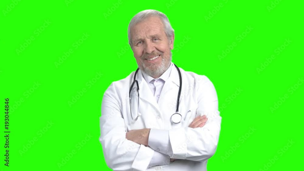 Elderly doctor with stethoscope, green screen. Smiling senior doctor crossed arms on chroma key background. Medicine and healthcare concept. Elderly doctor with stethoscope, green screen. Smiling senior doctor crossed arms on chroma key background. Medicine and healthcare concept.
