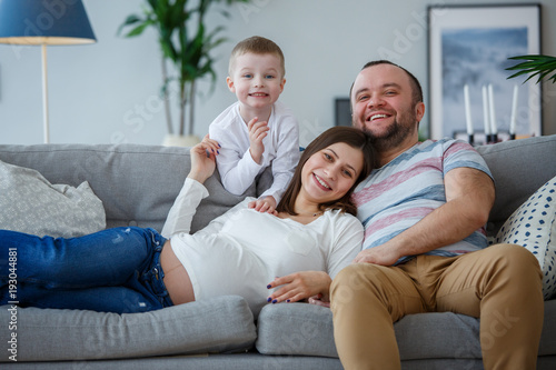 Picture of happy parents with small son on sofa