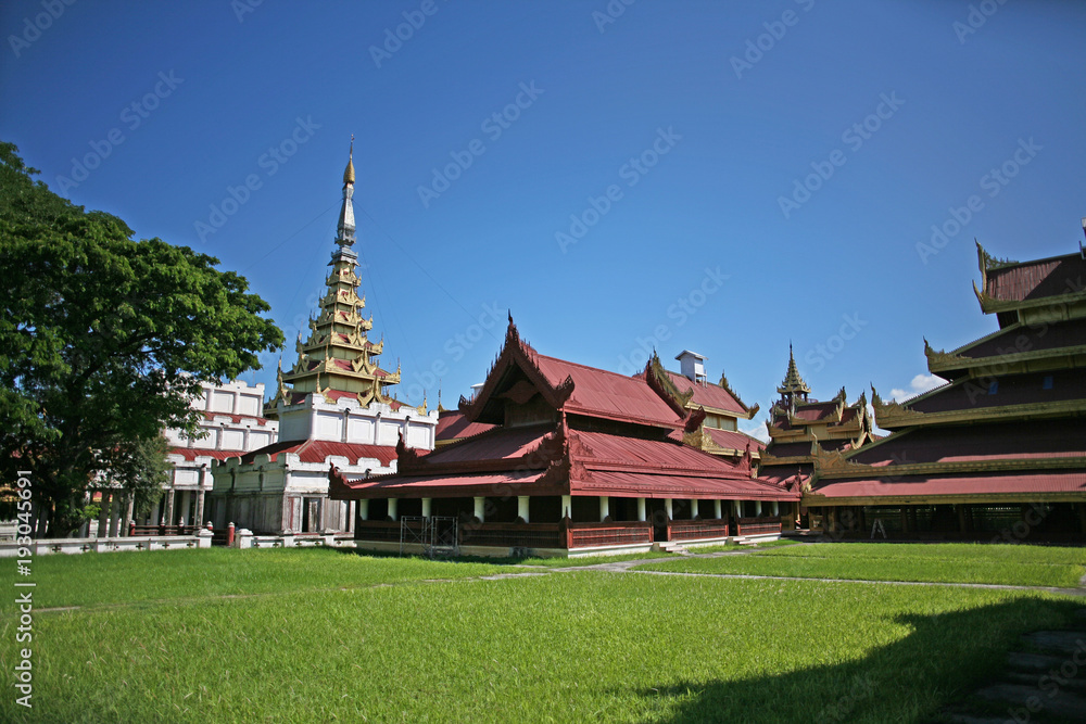 The golden spires and rooves of the historical wooden buildings within the central palace complex of the Mandalay citadel in Burma