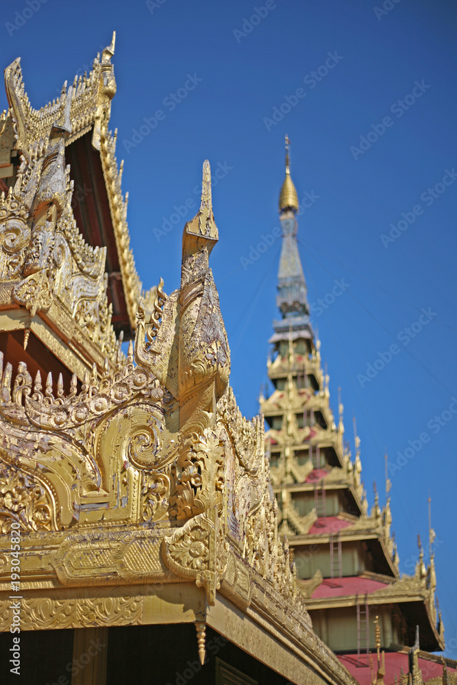 The golden and shimmering spires of a Burmese Palace in Mandalay, Myanmar