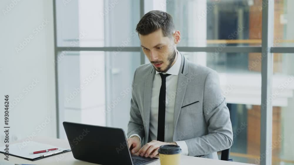 Young businessman using laptop computer receiving good message and become very excited and happy sits in modern office Young businessman using laptop computer receiving good message and become very excited and happy sits in modern office