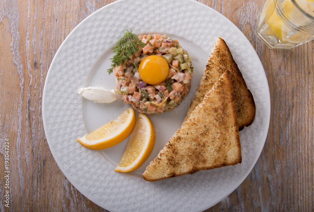 fish tartare salmon with yolk and toast on a plate fish tartare salmon with yolk and toast on a plate