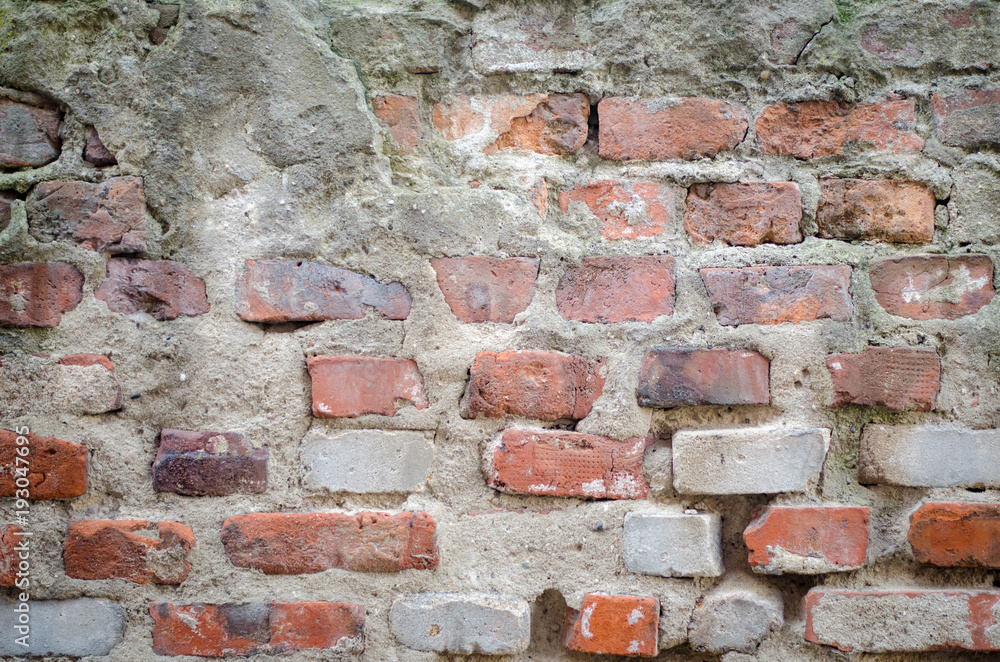 old grey concrete garage wall with red bricks and cracks abstract background old grey concrete garage wall with red bricks and cracks abstract background