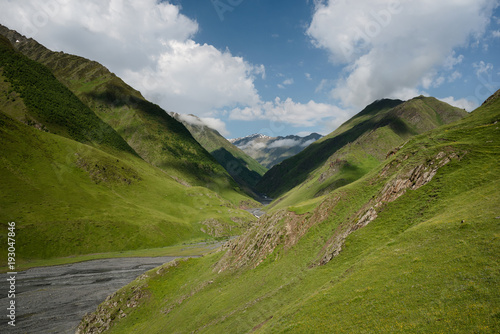 Landscape of a mountain valley with view at mountain river and mountain range.