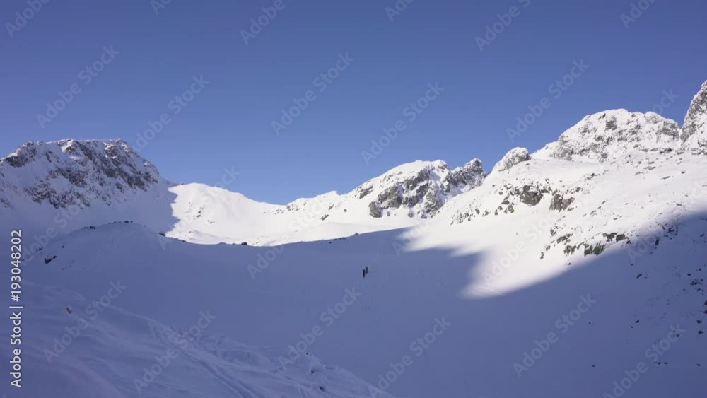 Ski touring in rocky mountains landscape covered in snow during cold sunny weather Ski touring in rocky mountains landscape covered in snow during cold sunny weather