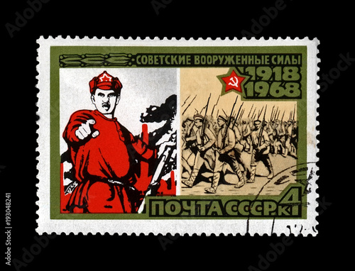 vintage poster and marching military volunteers, 50th anniversary of the Armed Forces of the USSR, circa 1968. canceled vintage postal stamp printed in the Soviet Union isolated on black background.