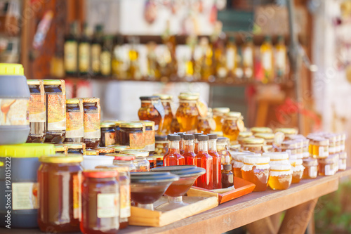 Honey in glass jars and bottles on the counter. Selling delicious and healthy product.