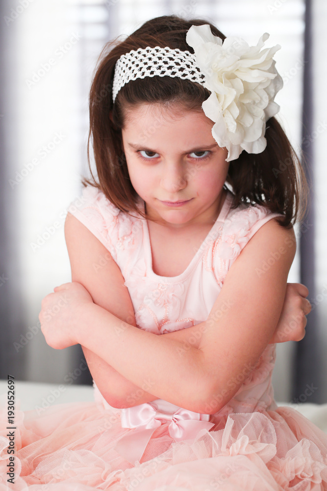 6 or 7 Years Old Little girl with Dark Hair and Brown Eyes, with White  Flower Headband,Funny Expression, sad, angry, posing isolated on blurry  background Stock Photo | Adobe Stock