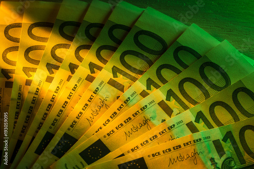 Ten Euro banknotes tidy with a yellow light coming from the left and a green light from the right