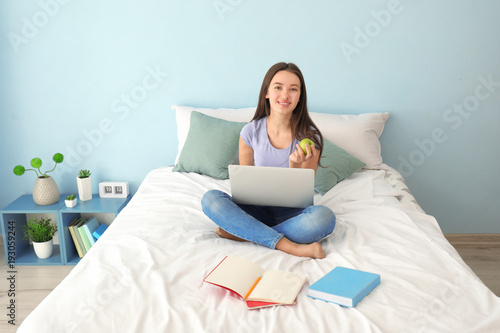 Cute teenager girl using la...