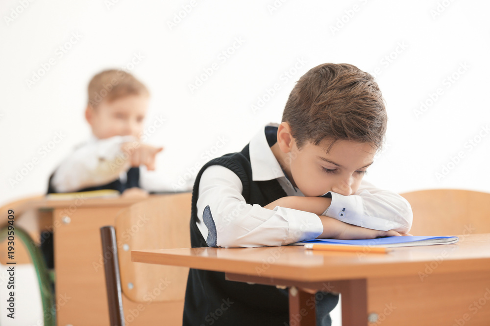 Bullied little boy in classroom Bullied little boy in classroom