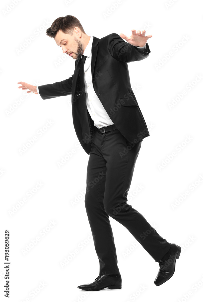 Young businessman balancing on white background
