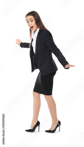 Young businesswoman balancing on white background