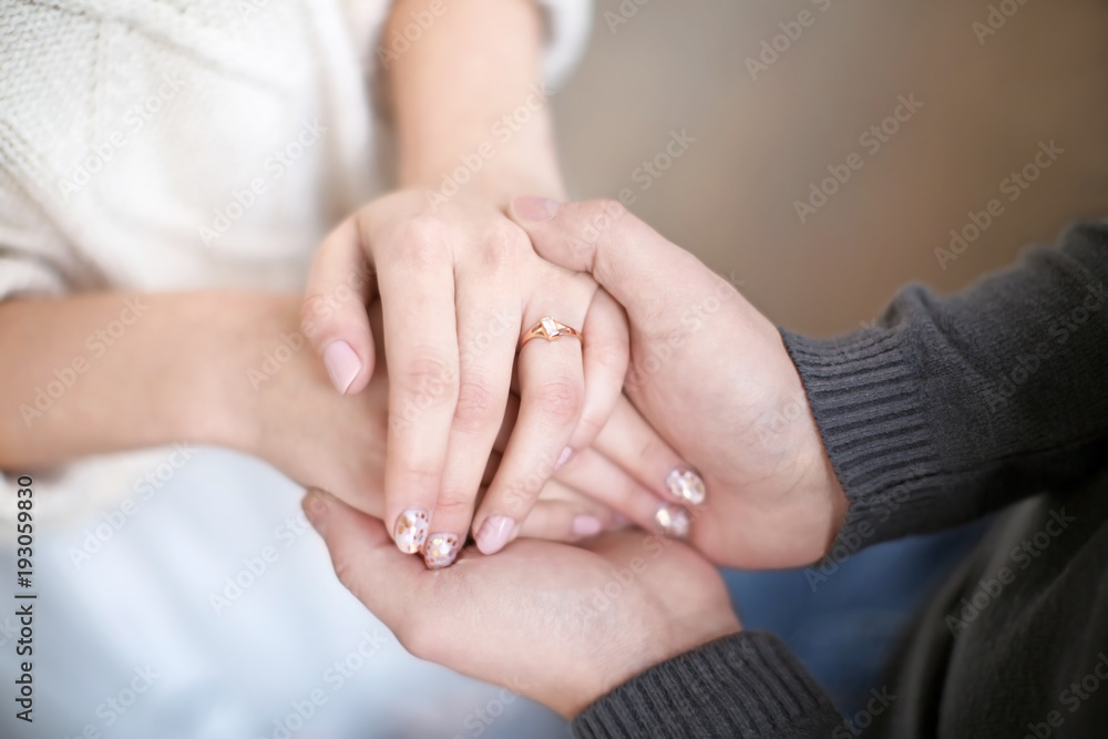 Young man holding hands of his beloved wife, closeup Young man holding hands of his beloved wife, closeup