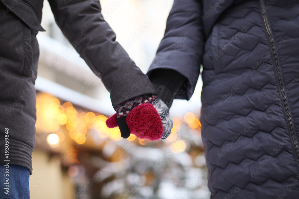 Fototapeta premium Young loving couple holding hands outdoors on winter day