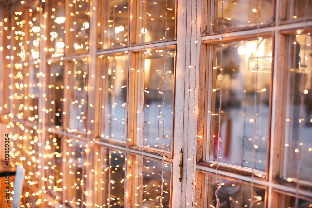Naklejka premium Beautiful Christmas lights on window, closeup