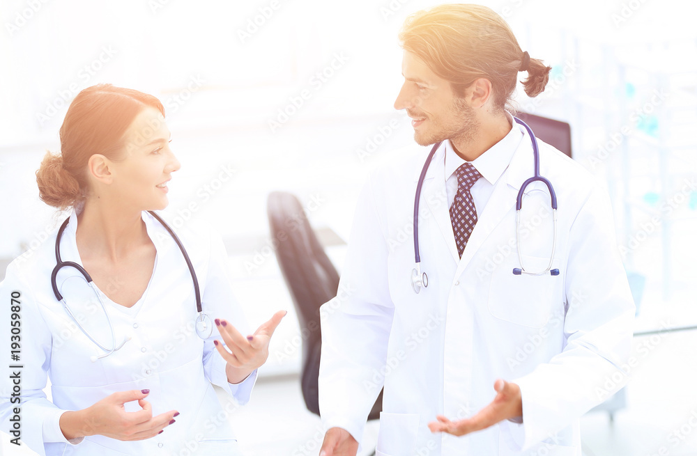 Two Doctors Having Meeting In Hospital Reception Area Two Doctors Having Meeting In Hospital Reception Area